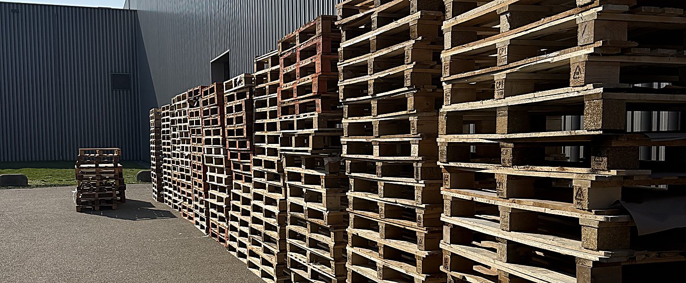 Rijen gestapelde overtollige pallets op het terrein, klaar voor inkoop